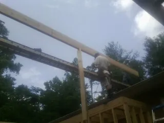 Carpenter setting a ridge beam over a new addition frame — Ice Dam Removal by Roofing Brothers in Little Hocking