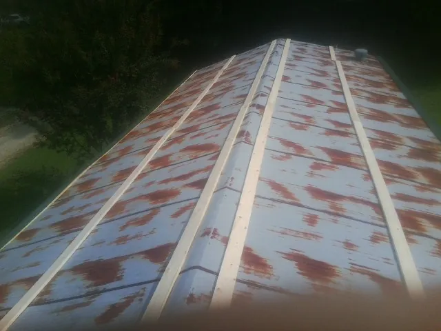 Rusted metal roof panels with new wood purlins before replacement — Storm Damage Roof Repair in Little Hocking by Roofing Brothers