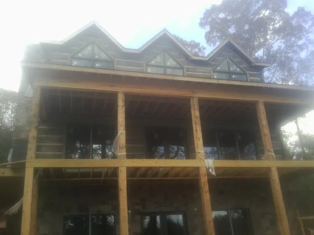 Dormers and porch framing on a large log home under construction — Roof Coating work by our crew in Little Hocking