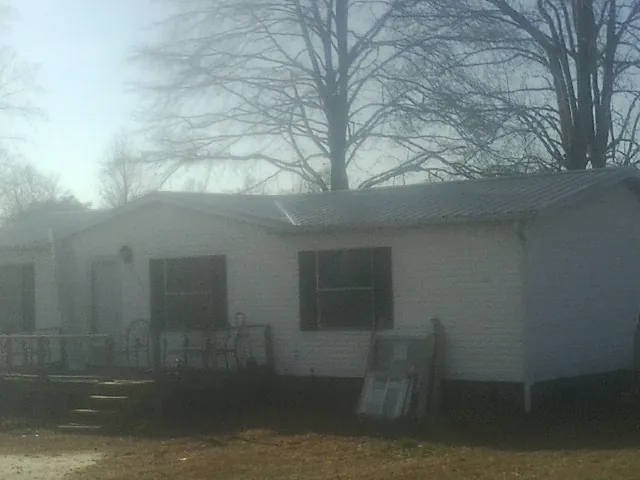 New metal roof on a white painted brick home on a foggy morning in Little Hocking