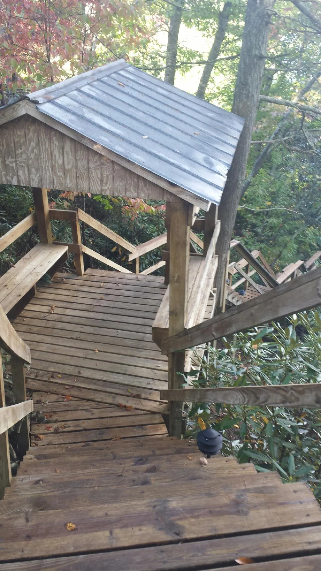 Metal roofed shelter over wooden steps on a wooded walkway — Skylight Repair & Installation work by our crew in Little Hocking