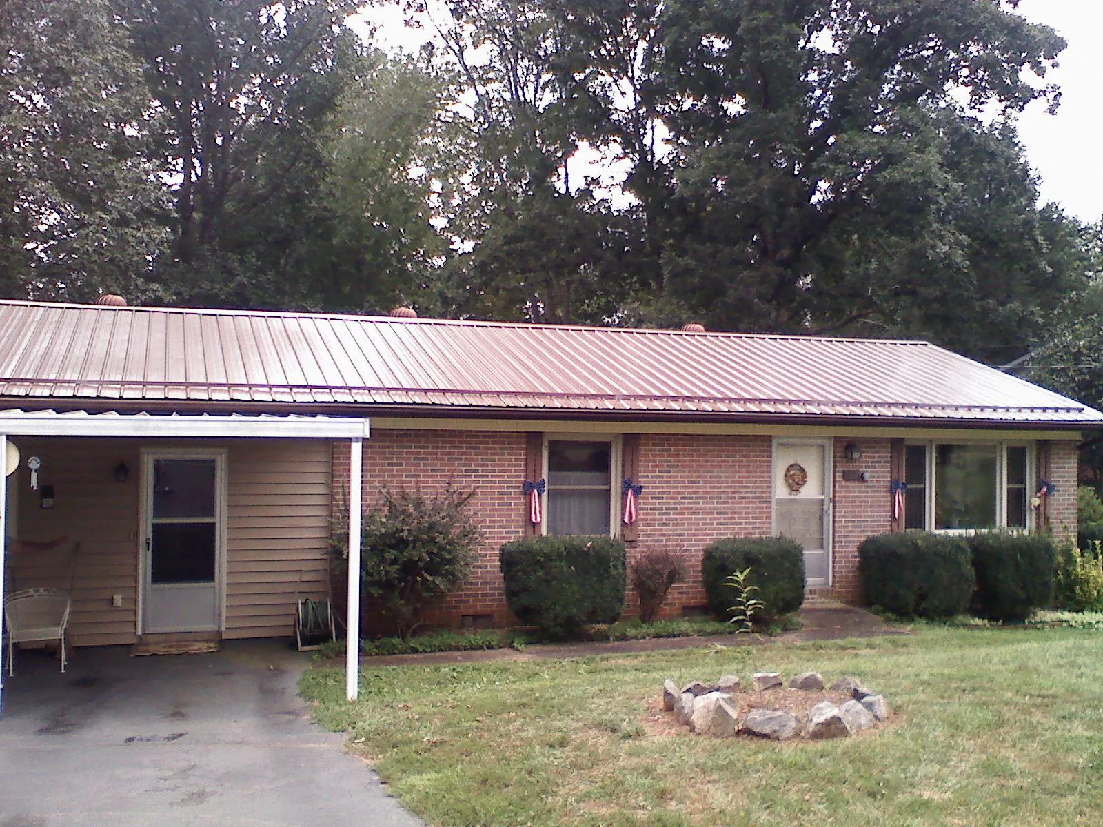Bronze metal roof and carport on a brick ranch home — Roof Repair work by our crew in Little Hocking